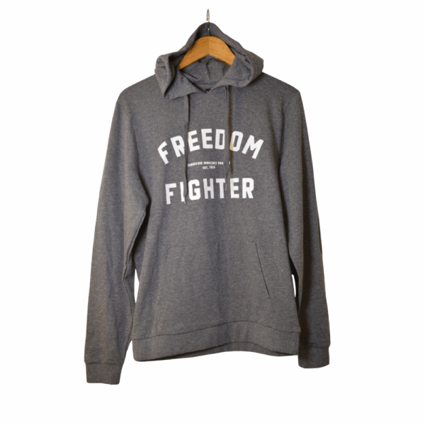 Gray Tennessee Innocence Project Freedom Fighter hoodie on a wooden hanger