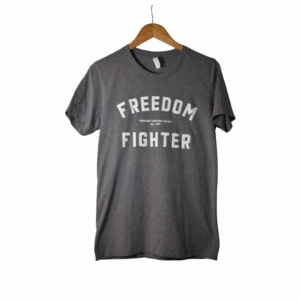Gray Tennessee Innocence Project Freedom Fighter t-shirt on a wooden hanger
